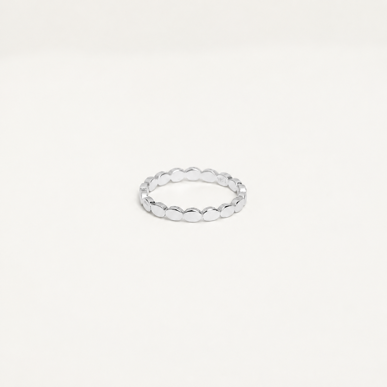 Silver ring on a light gray background